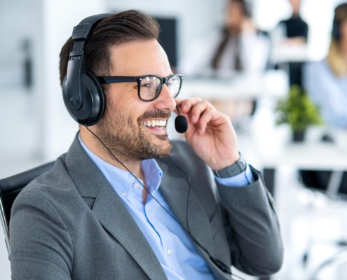 Side view of an outsourced IT professional taking a call on a headset